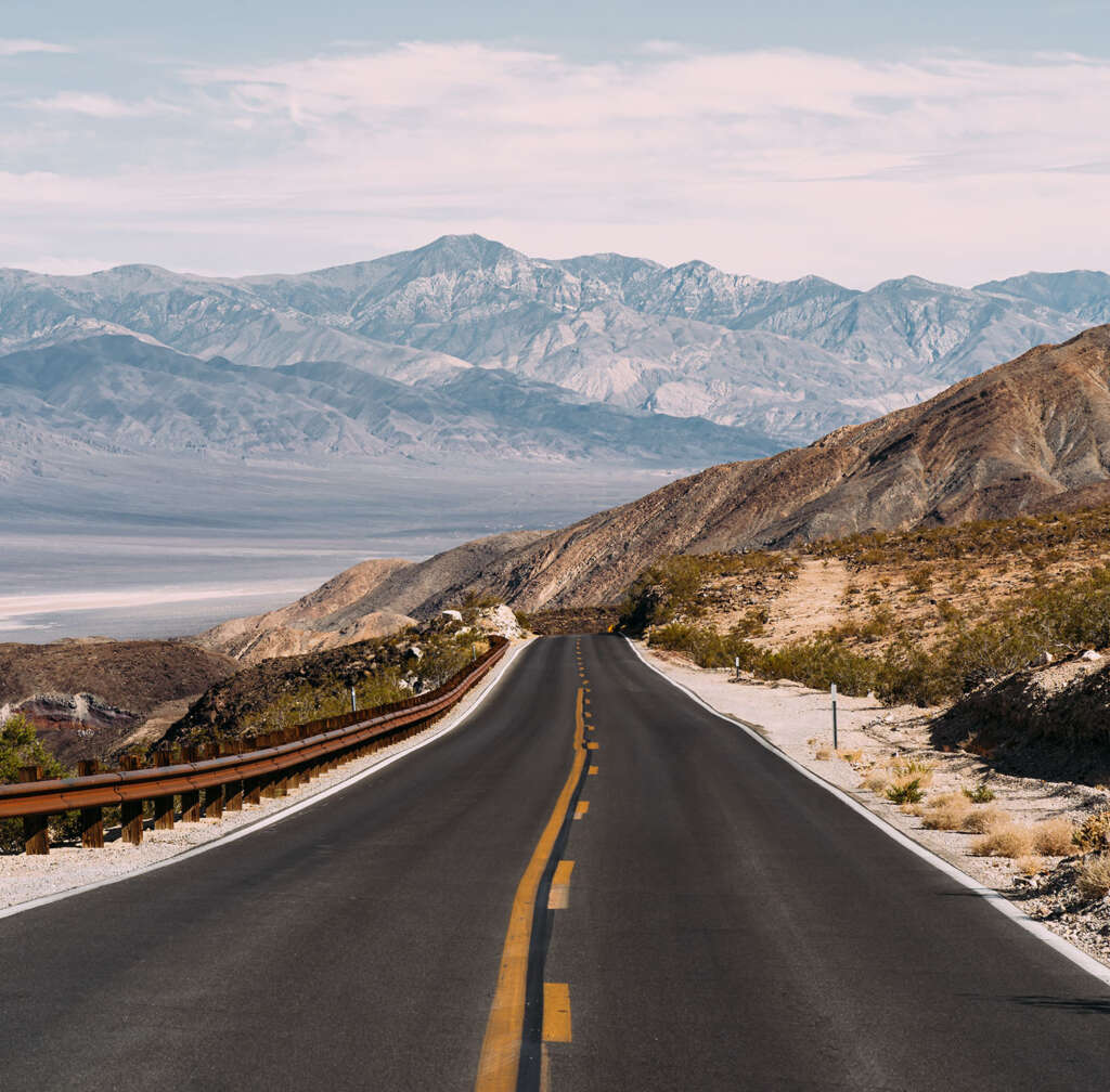 Empty mountain highway under a cloudy sky
