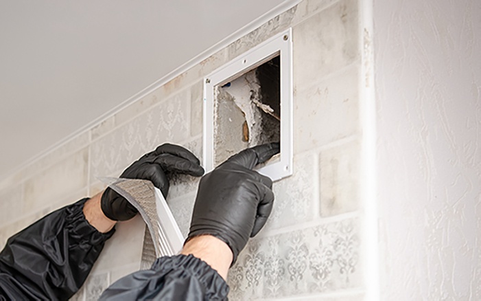 Duct cleaner removing duct facing to examine dirty duct