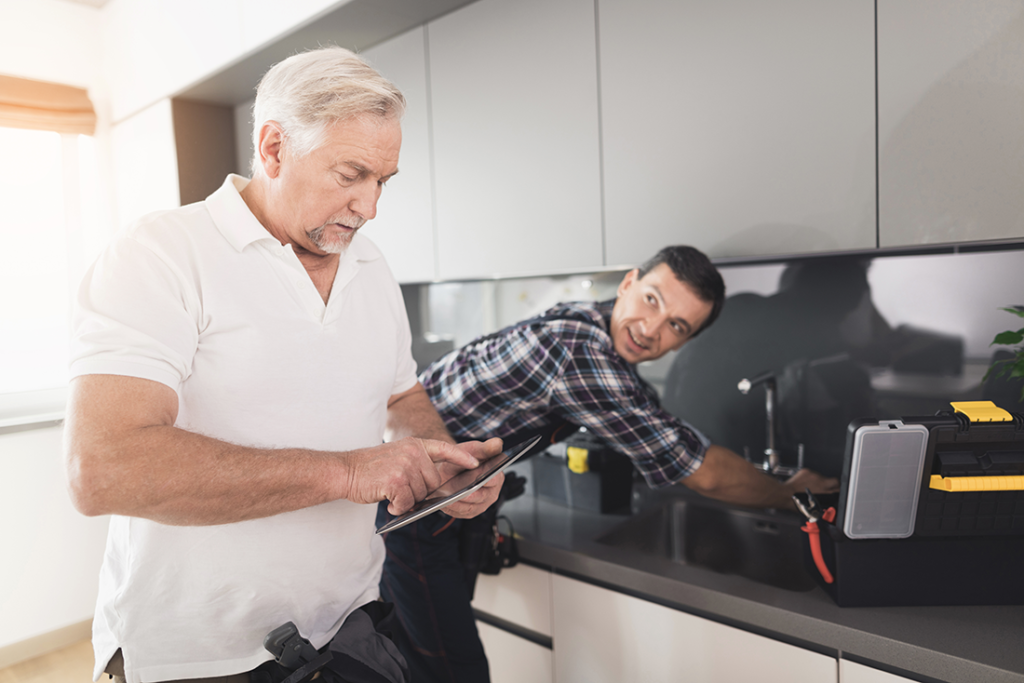 Customer signs off on the job while the plumber works on the faucet
