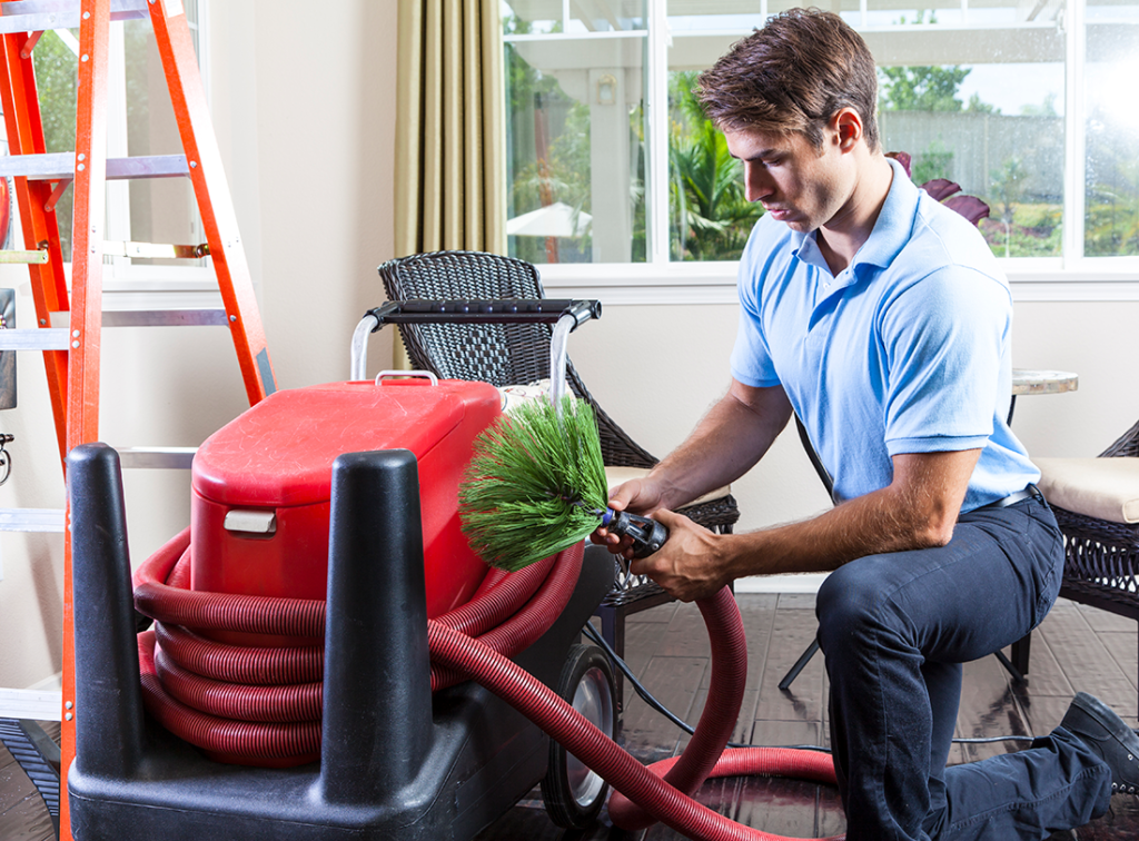 HVAC Tech preps a professional duct cleaning machine for a job