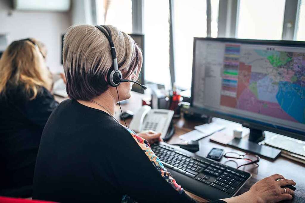 Office workers take calls and schedule technicians for service