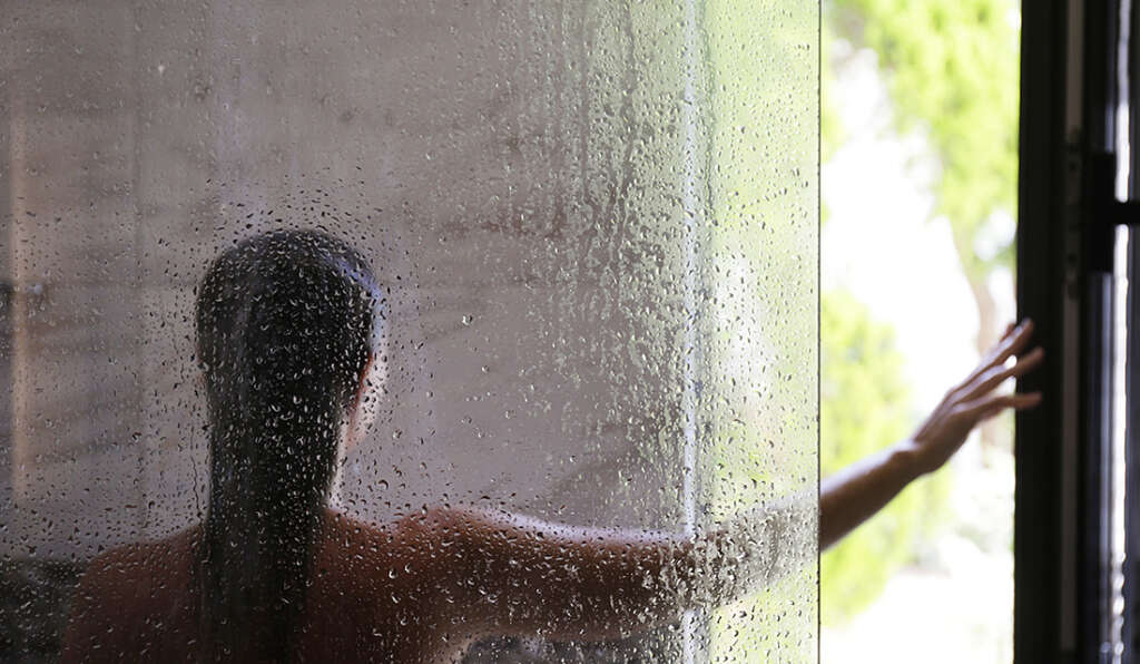 Woman opens the window in a steamy shower stall