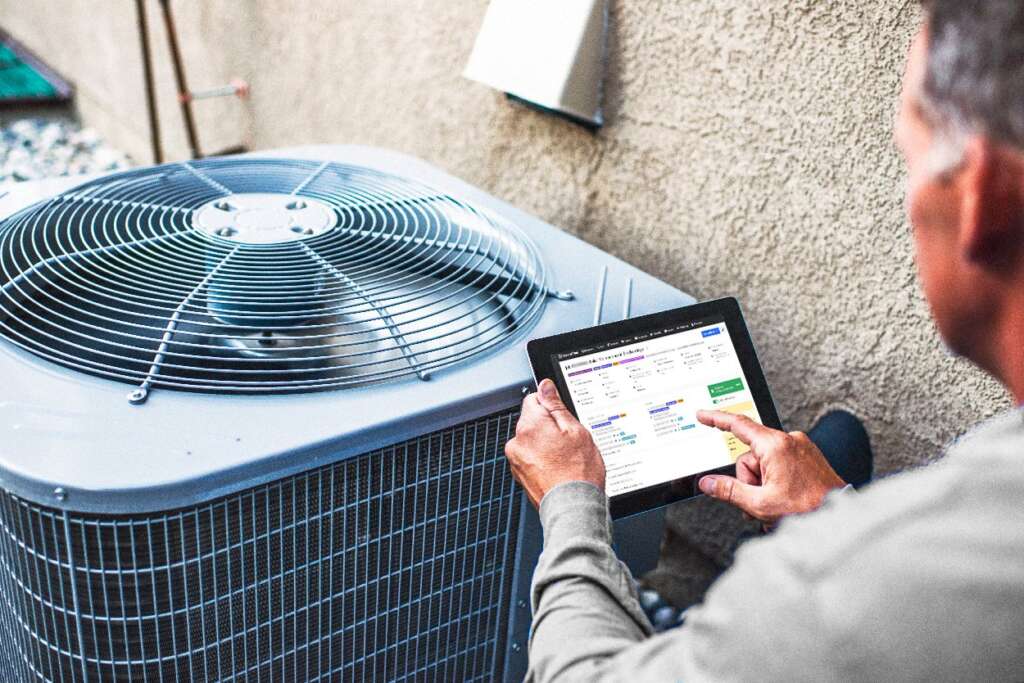 Technician records notes in ServiceTitan while performing and air conditioning maintenance